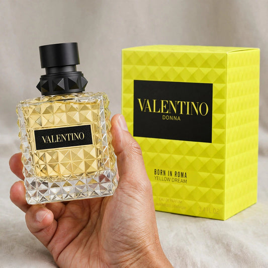 Hand holding Valentino Donna Born In Roma Yellow Dream EDP perfume bottle