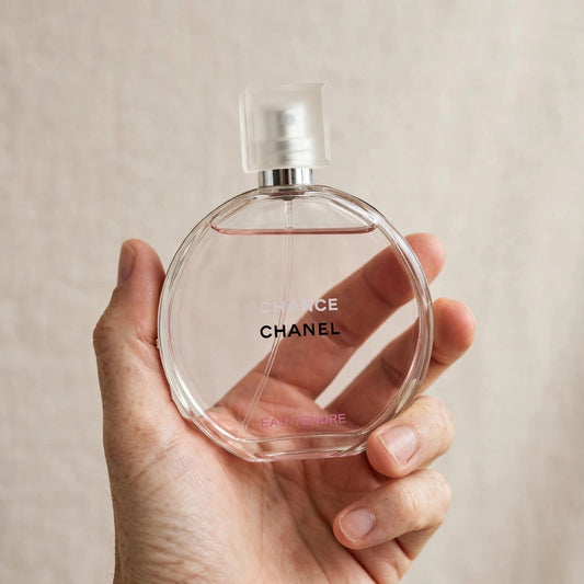 Hand holding Chanel Chance Eau Tendre perfume bottle