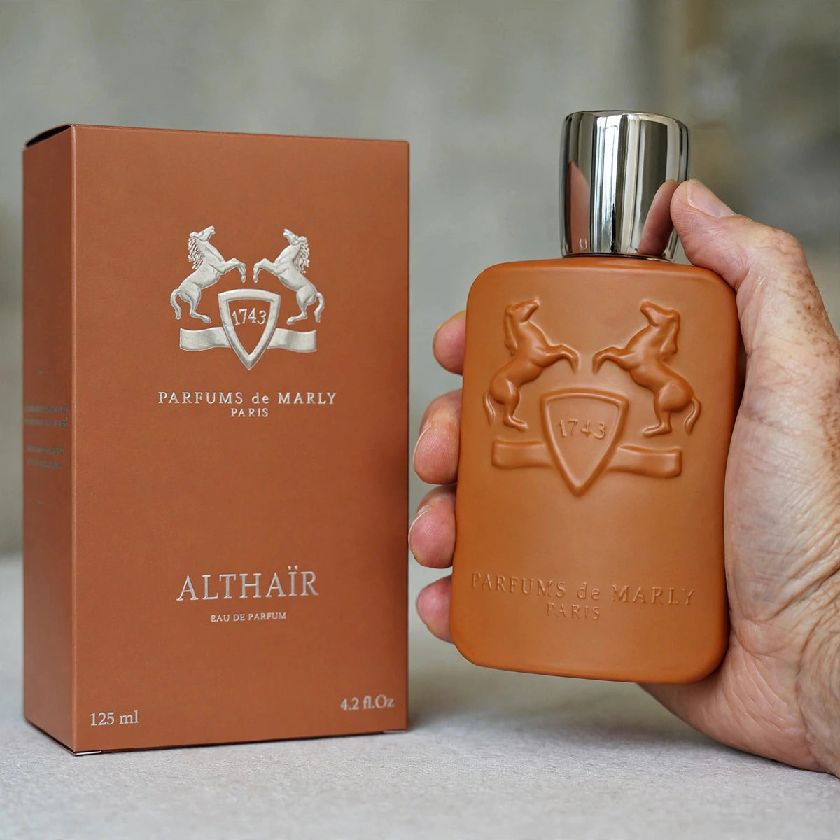 Hand holding Parfums de Marly Althair 125ml bottle