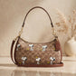 Coach x Peanuts Teri Shoulder Bag with Snoopy print in a warm beige studio