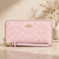 Coach CW778 long zip-around wallet in powder pink in a warm beige studio