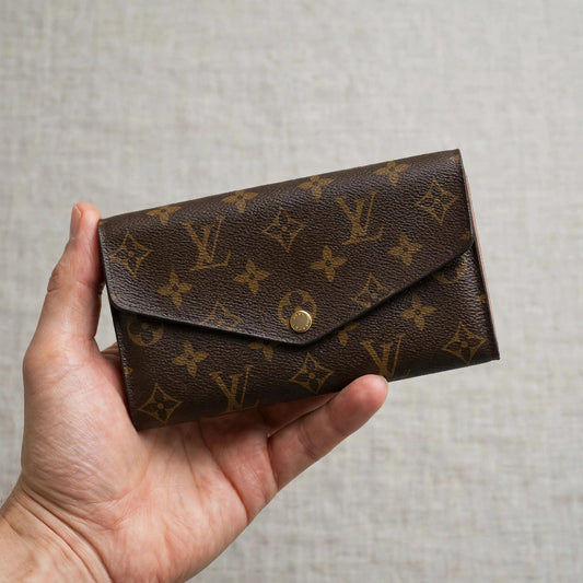 Louis Vuitton Portefeuille Sarah monogram long wallet held in hand