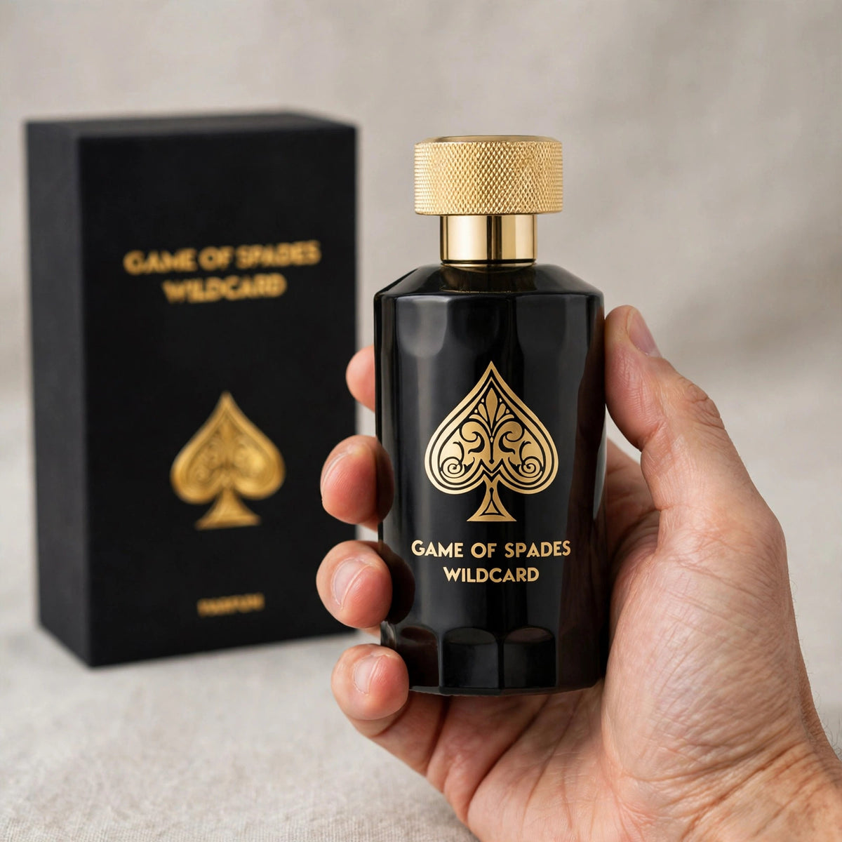 Hand holding Jo Milano Game of Spades Wildcard Parfum 100ml bottle