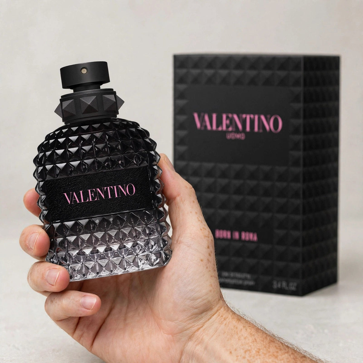 Hand holding Valentino Born In Roma EDT perfume bottle
