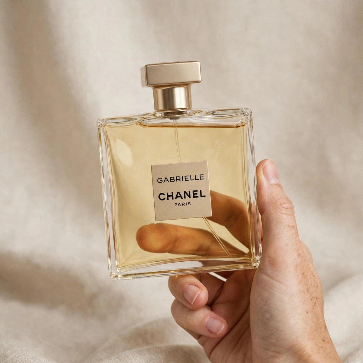 Hand holding Chanel Gabrielle Eau de Parfum perfume bottle