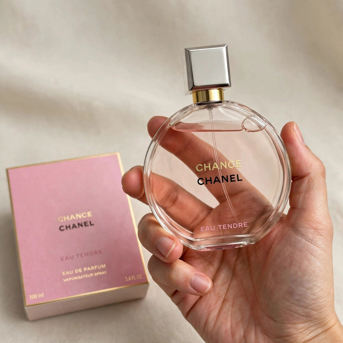 Hand holding Chanel Chance Eau Tendre EDP perfume bottle