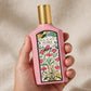 Hand holding Gucci Flora Gorgeous Gardenia EDP perfume bottle