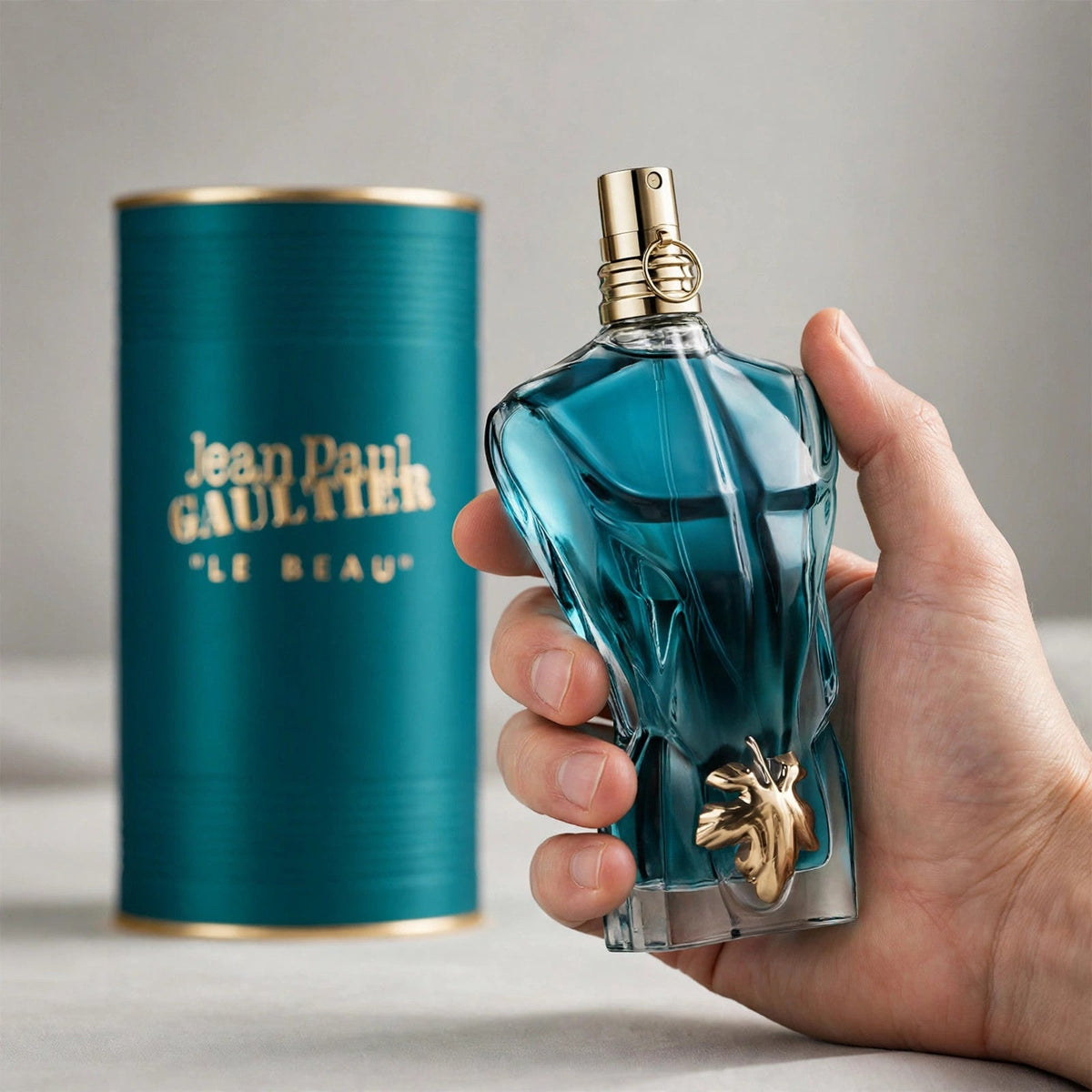 Hand holding Jean Paul Gaultier Le Beau EDT perfume bottle