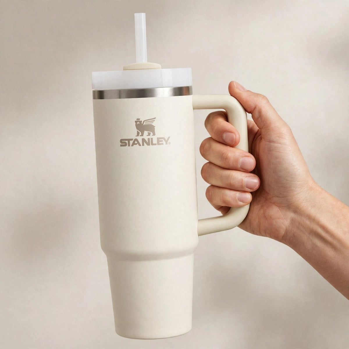 Hand holding the Stanley Quencher 30oz cream tumbler
