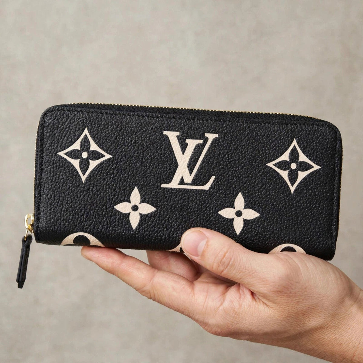 Hand holding the Louis Vuitton Portefeuille Clémence wallet