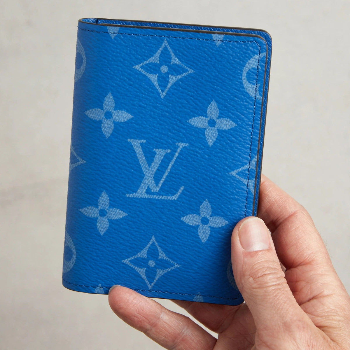 Hand holding the Louis Vuitton Surfin’ Blue pocket organizer
