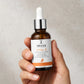 Hand holding Image Skincare Vital C ACE serum bottle