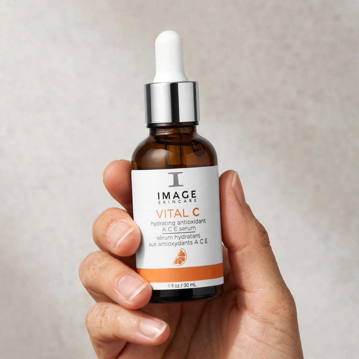 Hand holding Image Skincare Vital C ACE serum bottle