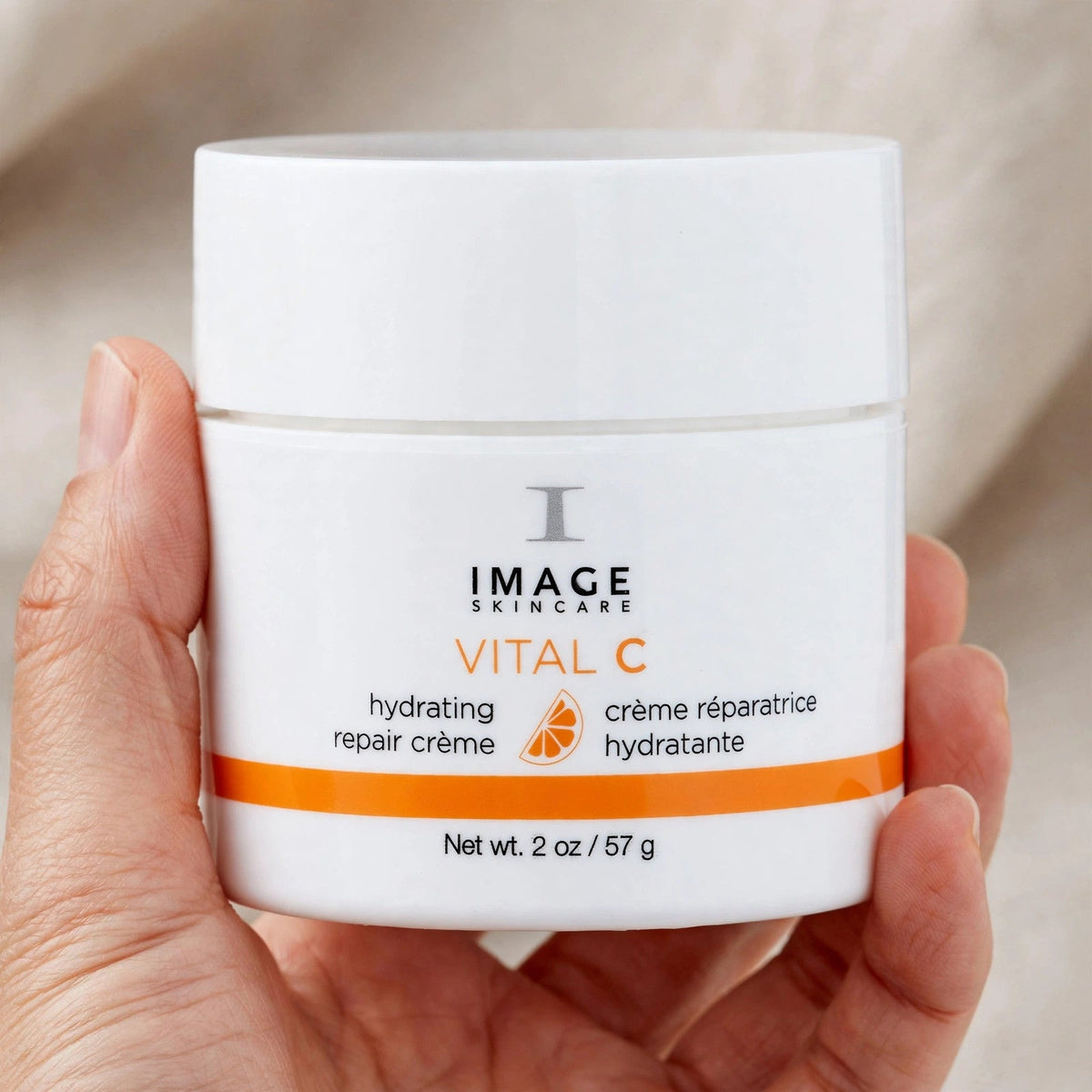 Hand holding Image Skincare Vital C Hydrating Repair Creme jar