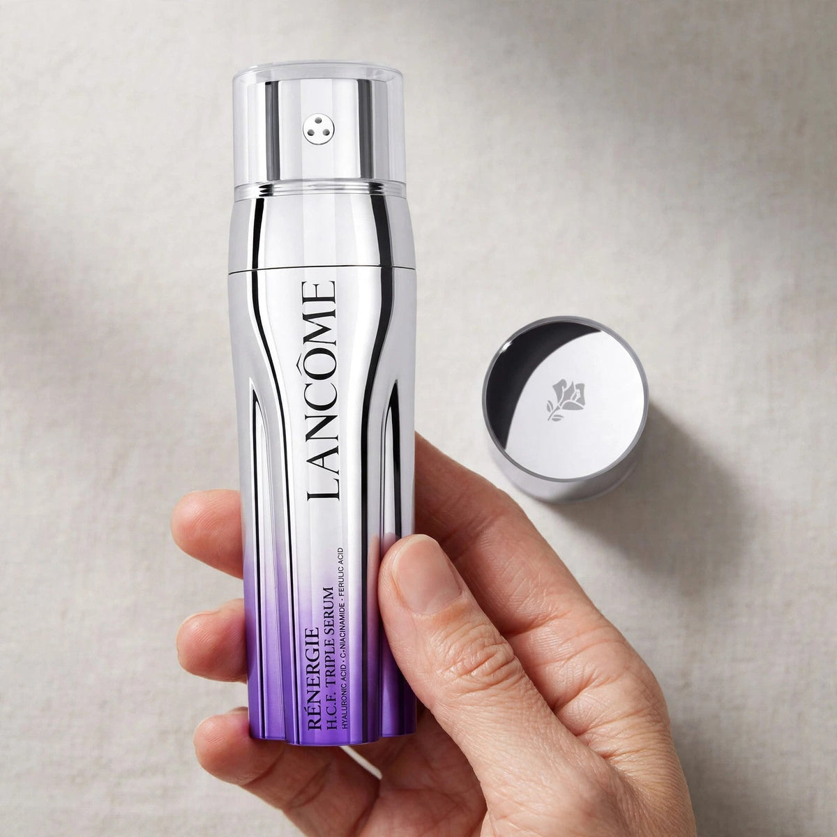 Hand holding Lancome Renergie HCF Triple Serum bottle