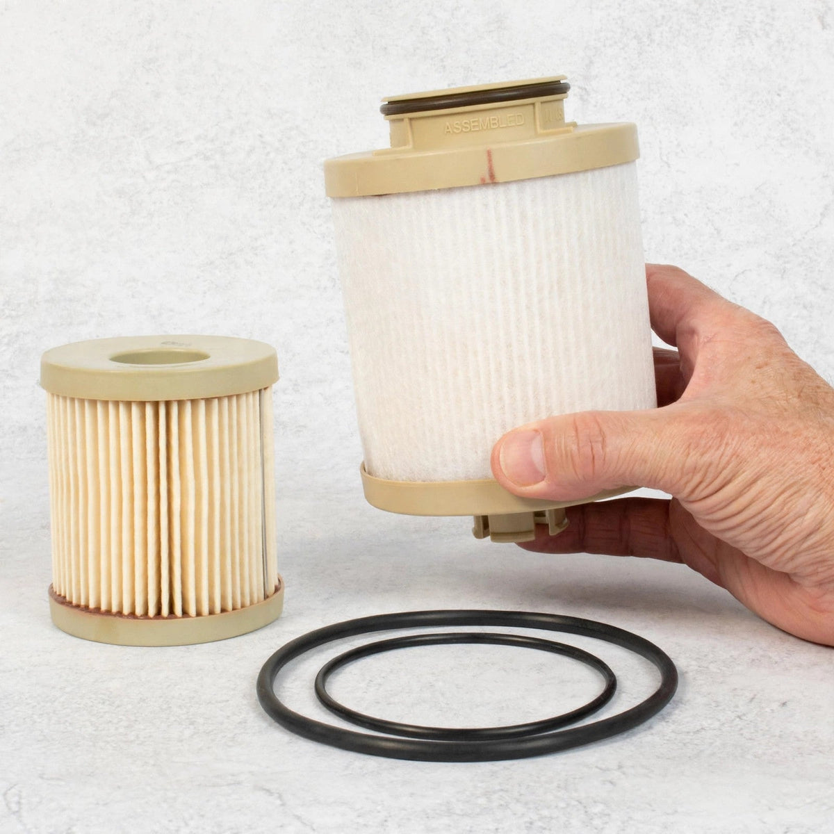 Hand holding a Motorcraft FD-4616 diesel fuel filter element