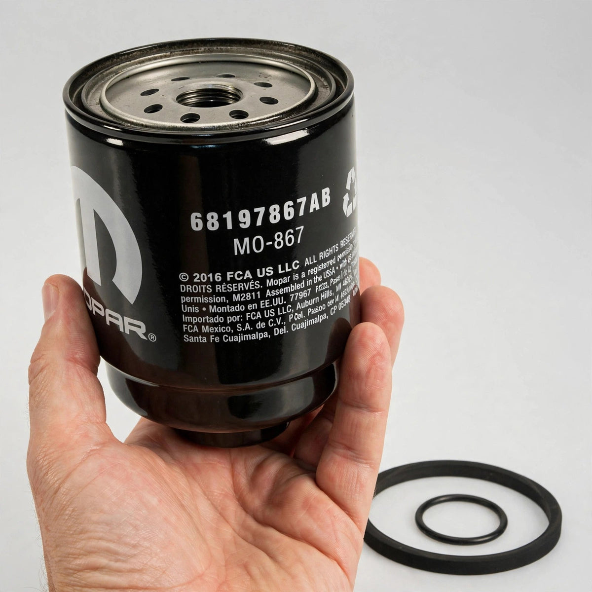 Hand holding a Mopar 68197867AB fuel/water separator filter